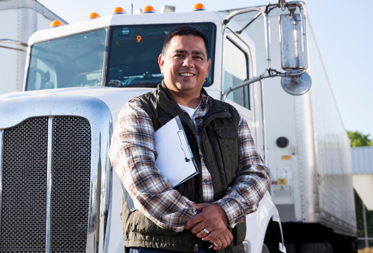 Auto Liability Ten Four Truck Insurance Fleet Coverage Man with clipboard standing in front of white semi truck