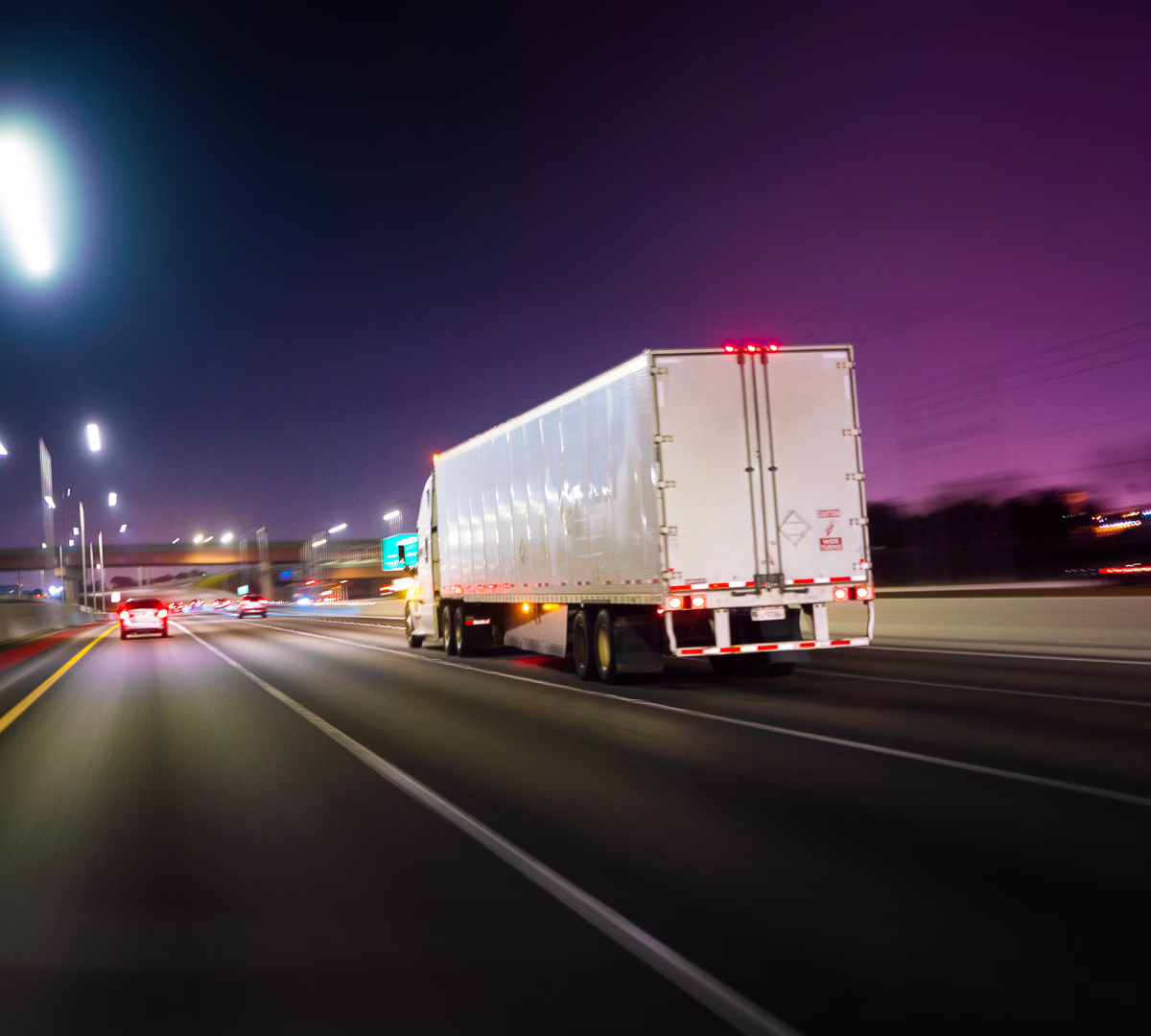 Semi truck and trailer going down a highway